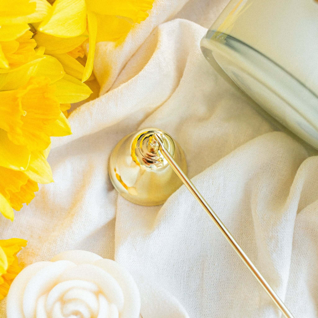 Close-up of gold candle snuffer showing polished finish and detailed craftsmanship