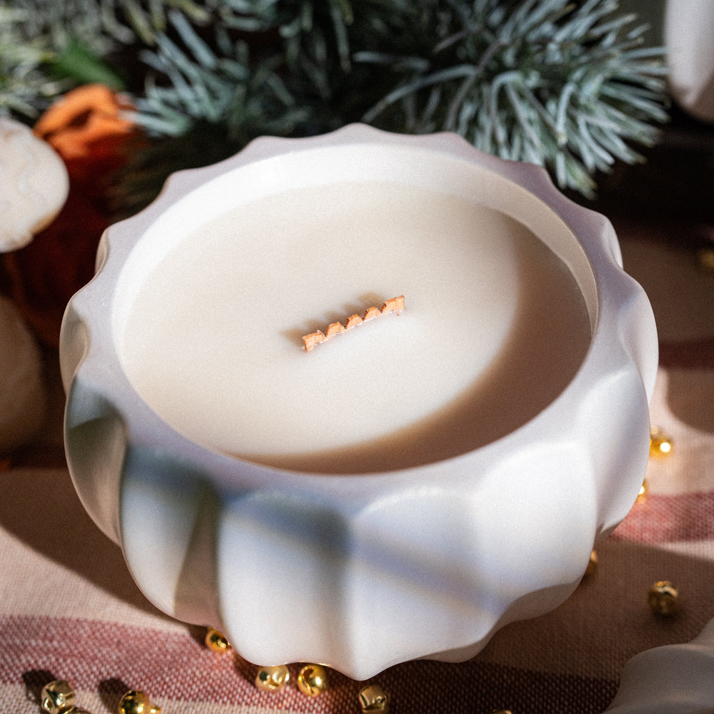 Rokām darināta Ziemassvētku bumbas formas svece tuvplānā – sojas vasks un koka dakts