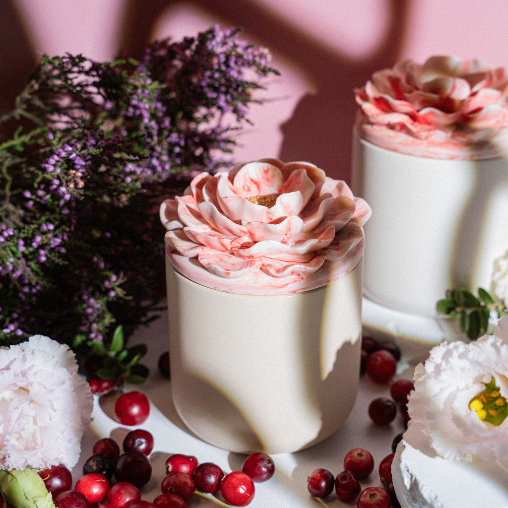 Handmade aromatic candle with cranberry fragrance in floral container