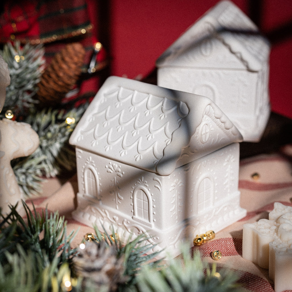 Handcrafted holiday candle shaped as a gingerbread house centerpiece from Latvia