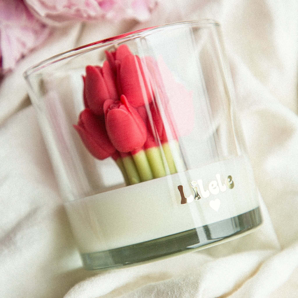 Close-up of handmade soy wax candle with tulip embeds in a clear glass jar by Lilele Studio